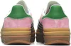 The back view of two pink Adidas Gazelle Bold W sneakers with green accents and a stacked brown sole. Produktbild-Vorschau