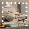A vanity mirror with LED lights is placed on a dresser in front of a bed. Produktbild-Vorschau