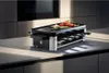 A WMF Lono Selection Raclettegrill is shown on a kitchen countertop with food on top. Náhľad obrázku produktu