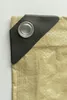 A close-up view of a corner of a tan tarp with a black reinforced grommet. Produktbild-Vorschau