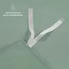 Close-up of a green fabric with white ribbons attached, suggesting a bedding product feature. Voir les images du produit