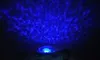 A projection of blue light patterns on a dark surface, emanating from a small device at the bottom. Voir les images du produit