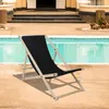 A black deck chair is placed on a patio next to a swimming pool. Produktbild-Vorschau
