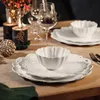 A festive table setting with candles, plates, and wine glasses. Voir les images du produit