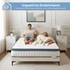 A couple in bed, one using a laptop while the other sleeps, with a mattress prominently displayed. Náhled obrázku produktu