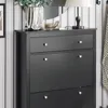 A close-up view of a black shoe cabinet with silver knobs, set against a striped wallpaper background. Náhľad obrázku produktu