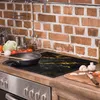 A kitchen counter with a stove, cooking utensils, and ingredients. Náhľad obrázku produktu
