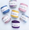 A collection of YarnArt Linen Soft yarn skeins in various colors, arranged in a circular pattern on a light blue background. Produktbild-Vorschau