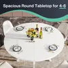 A round white dining table set for four people with place settings, wine bottles, and a floral centerpiece. Náhled obrázku produktu