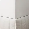 A close-up view of a white mattress protector, showing its quilted texture and corner. Podgląd zdjęcia produktu