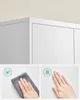Close-up of a white cabinet with two inset images showing features: one with a hand wiping the surface and another with a hand touching the surface, indicating fingerprint resistance. Náhled obrázku produktu