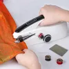 A person is using a portable sewing machine to sew an orange fabric. Produktbild-Vorschau