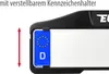A close-up of a license plate holder with a German license plate inserted, showing adjustable height. Produktbild-Vorschau