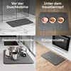 Collage showing a dark gray mat used in four different scenarios: in front of a shower, under pet bowls, as a dish drying mat, and as a kitchen mat. Produktbild-Vorschau