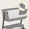 A close-up view of a gray baby bassinet with a white liner, and a rolled-up gray strap in a circular overlay in the top right corner. Náhľad obrázku produktu