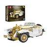 A white and gold vintage car model is displayed in front of its packaging. Voir les images du produit