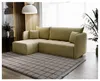 A sectional sofa is shown in a living room setting, placed on a rug in front of a window with sheer curtains. Produktbild-Vorschau