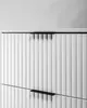 A close-up view of a white matte cabinet with ribbed doors and black handles. Produktbild-Vorschau