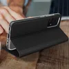 A black phone case is propped up on a wooden surface, with a person's hand in the background. Produktbild-Vorschau