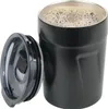 A black insulated coffee cup with its lid off, sitting next to it. Anteprima dell’immagine prodotto