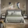 A bedroom scene with a bed, nightstands, and artwork. Voir les images du produit