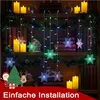 A decorated shelf with Christmas lights, candles, and decorative items. Produktbild-Vorschau