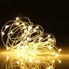 A tangled string of warm white LED lights on a dark background, with a reflection on a shiny surface. Produktbild-Vorschau
