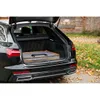The image shows the interior of a car trunk with a foldable dog crate placed inside. Produktbild-Vorschau