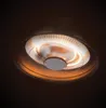 A close-up, low-angle shot of a circular ceiling heater with glowing orange heating elements. Produktbild-Vorschau