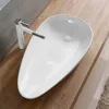 A white vessel sink with a modern chrome and white faucet is placed on a wooden countertop. Náhled obrázku produktu