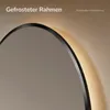 Close-up of a round mirror with integrated LED lighting, showing the frame and a hint of the light. Náhled obrázku produktu