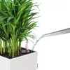 A white planter with a green plant being watered from a watering can. Podgląd zdjęcia produktu