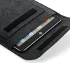 A tablet is placed inside a dark gray felt sleeve with velcro closures. Produktbild-Vorschau