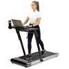 A woman is using a treadmill with a built-in desk and laptop. Podgląd zdjęcia produktu
