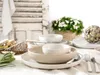 A table setting with plates, bowls, cutlery, cheese, and a flower arrangement. Náhľad obrázku produktu