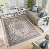 A living room scene with a large rug as the focal point, surrounded by furniture and decor. Produktbild-Vorschau