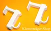 Two white curtain rod brackets are shown against an orange background. Produktbild-Vorschau