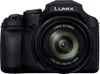 A black Panasonic Lumix digital camera is shown from the front against a white background. Produktbild-Vorschau