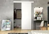 A modern interior scene featuring a white sliding door, a desk with a laptop, and decorative items. Náhled obrázku produktu