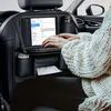 A person is using a tablet and keyboard attached to a car seat organizer while sitting in a car. Anteprima dell’immagine prodotto