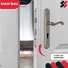 A close-up of a door handle and lock mechanism on a white door, with a red arrow indicating movement. Produktbild-Vorschau
