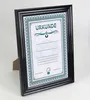 A framed certificate is displayed on a white background with a stand. Produktbild-Vorschau