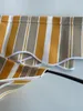 A close-up view of a striped awning fabric with a scalloped edge, held by a black pole. Produktbild-Vorschau