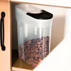 A clear plastic food storage container filled with cereal, placed on a shelf inside a cabinet. Produktbild-Vorschau