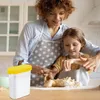 A mother and daughter are baking together in a kitchen, with a flour dispenser in the foreground. Produktbild-Vorschau