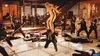 A scene from the movie Kill Bill: Volume 1, showing a woman in a yellow tracksuit fighting a group of men in black suits. Produktbild-Vorschau