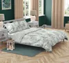 A bedroom scene with a bed dressed in a leaf-patterned duvet cover and pillows. Anteprima dell’immagine prodotto