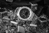 A close-up, black and white shot of a G-SHOCK watch surrounded by metallic ice cubes and pebbles. Náhled obrázku produktu