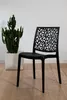 A black chair with a decorative back is placed next to a potted cactus in a white planter. Anteprima dell’immagine prodotto