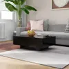 A modern living room scene with a black coffee table in the foreground, a grey sectional sofa with decorative pillows, and a large potted plant. Voir les images du produit
